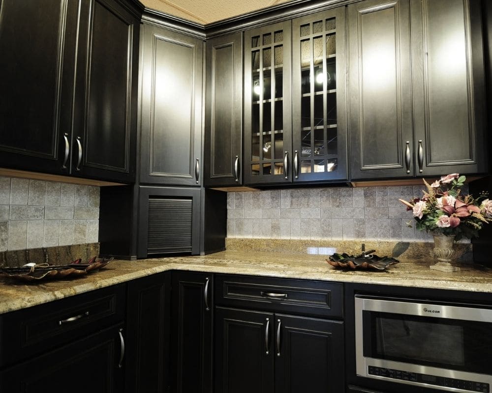 The same kitchen after cabinet painting, with cabinets sprayed a deep matte black